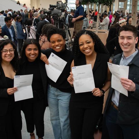 Students holding pieces of paper that show where they matched 