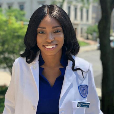 Tamia Potter wearing a white coat outside a building
