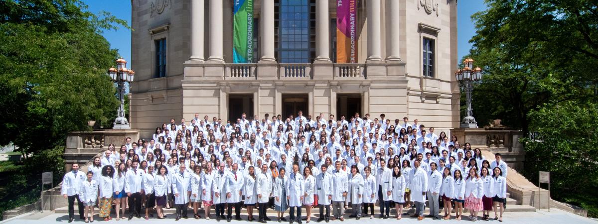 Students and faculty in their white coats