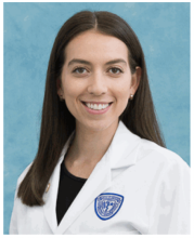 Female medical student smiling in white coat