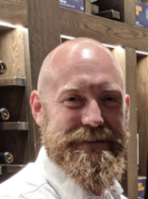 Man smiling with bald head and beard
