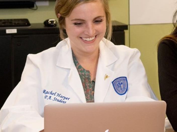 Two Physician Assistant students look at a laptop