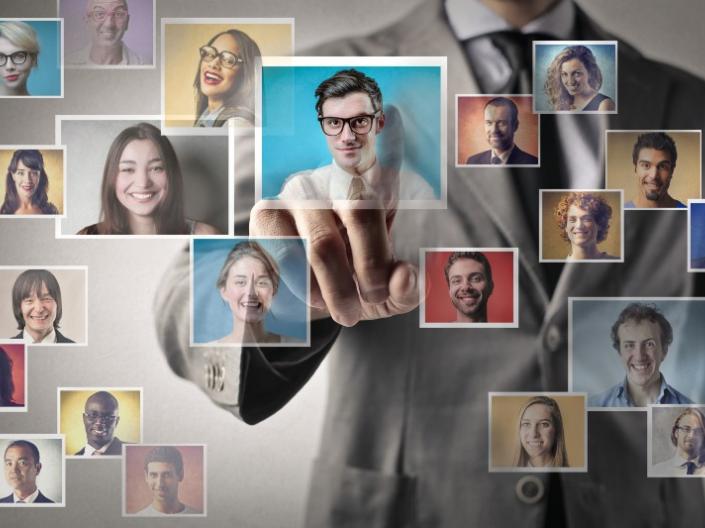 A man pointing at profile images of various people