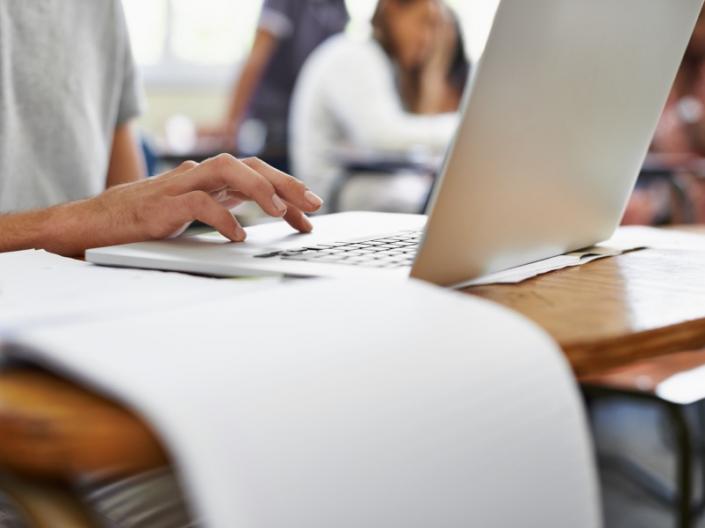 A woman typing on a computer at a desk