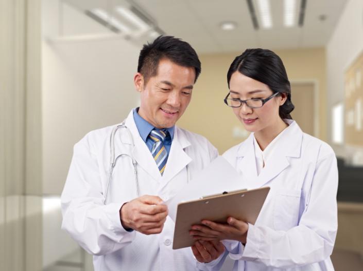 A doctor and student look over some charts