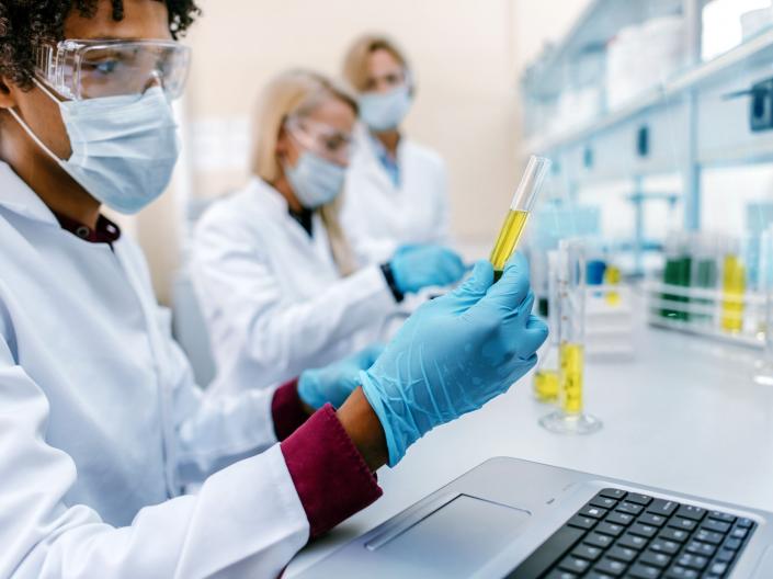 Team of scientists examining toxic liquid in a laboratory