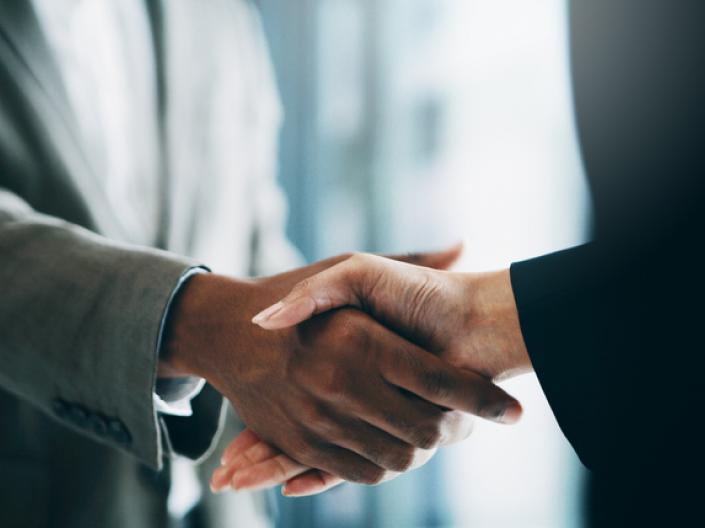 Close up of two diverse people shaking hands