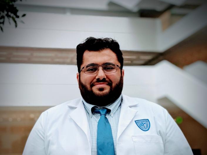 Photo of Suhib Jamal outside wearing a white coat