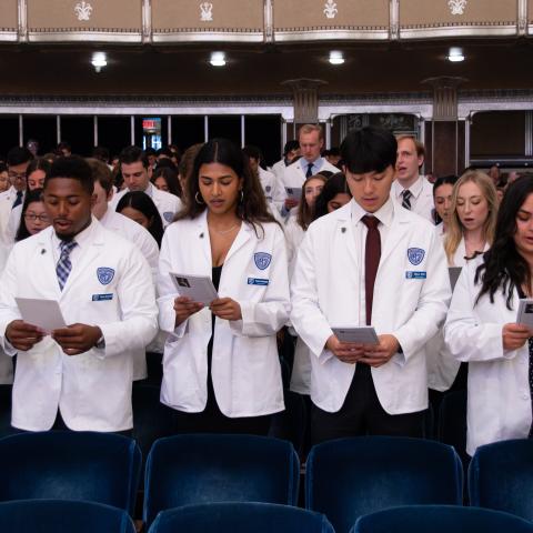 Students wearing white coats in Severance Hall 