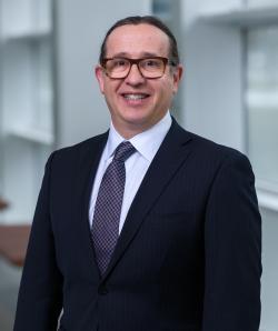 smiling man with glasses and dark suit