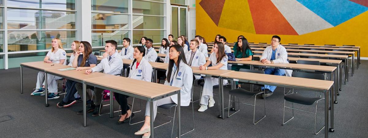 medical students sitting at tables in classroom