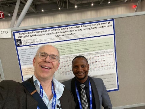 Oladayo Oyebanji standing in front of a poster board