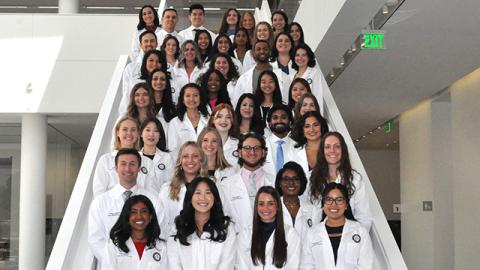 PA students wearing white coats in Health Education Campus atrium