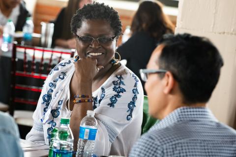 People in a discussion and a woman smiling.