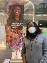Olubukola Abiona with poster that says "A black girl will save the world"