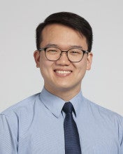 Photo of a smiling man wearing glasses and tie 