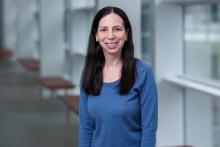 smiling woman with dark hair and blue shirt