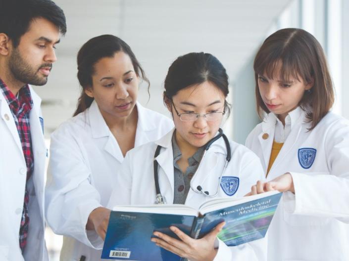 Medical students reading through a textbook together