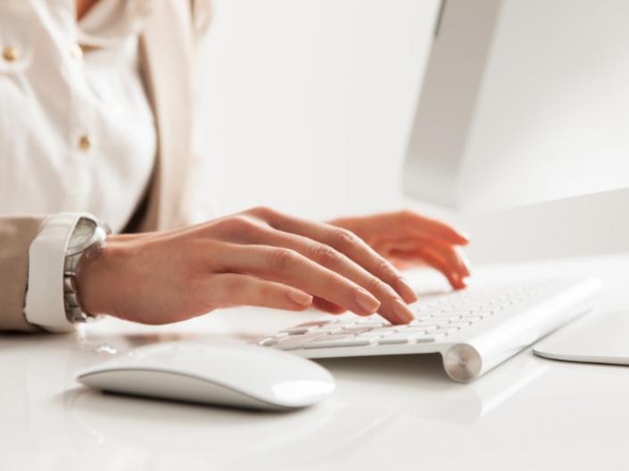 Close-up of a woman typing on a keyboard