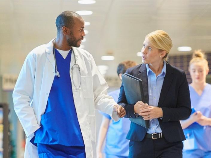 Two doctors talking while walking through a hallway
