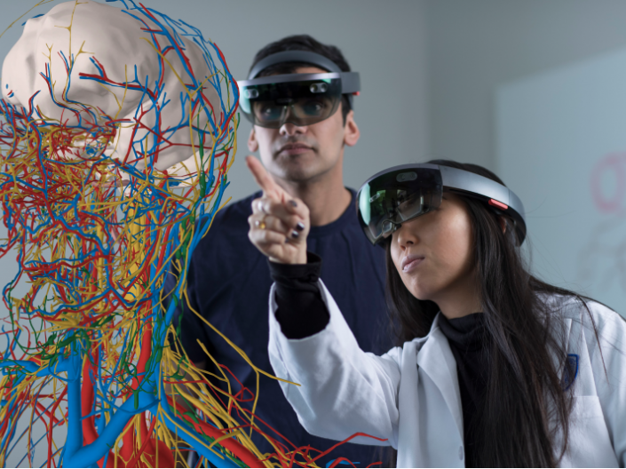 Two students using hololens equipment to analyze the human nervous system