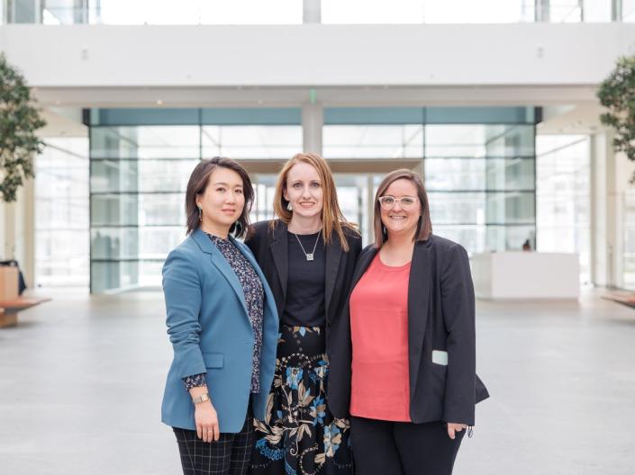 Three women pose for a photo together in the HEC building.