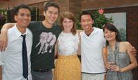 A group of friends smiling with their arms around each other.