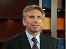Headshot of Dr. Jeffrey Marks with books behind him.