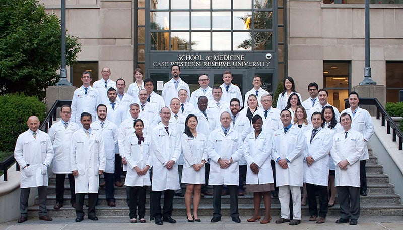 School of medicine staff in their white coats posing for a picture. 
