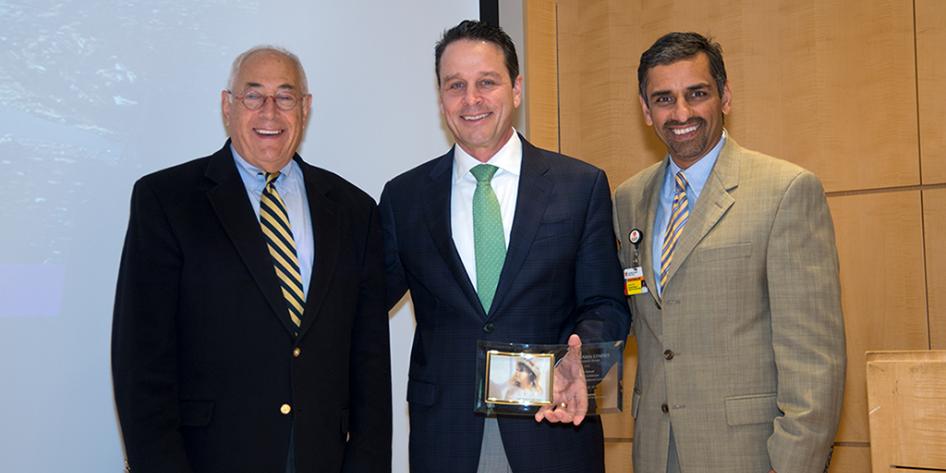 Drs. Goldstone, Starnes and Kashyap in suits and ties. Dr. Starnes holding a plaque.