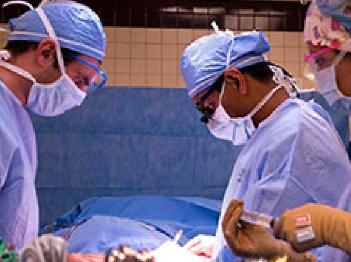 three surgeons working on OR theater all in blue gowns