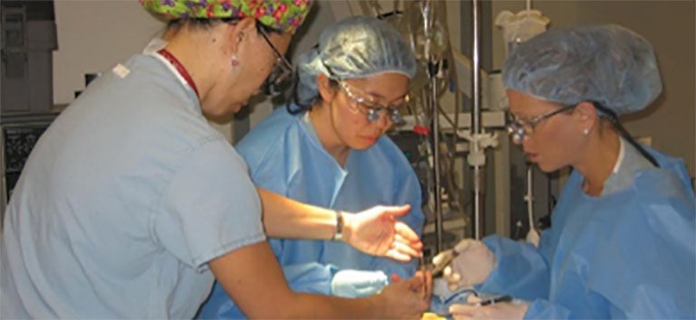 three surgeons working in OR theater