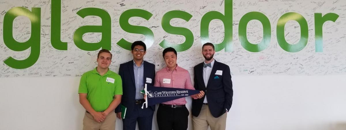 students dressed business casual  in front of a glassdoor logo