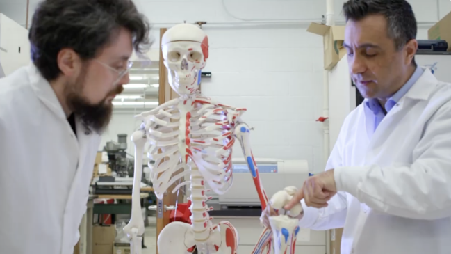 Ozan Akkus and student in the lab with a skeleton