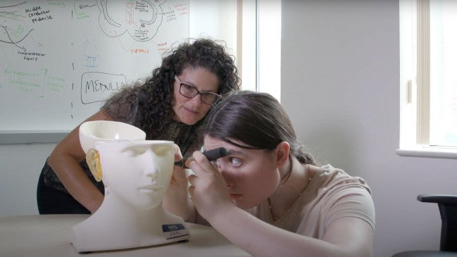 Lauren Calandruccio works with a student for hearing tests