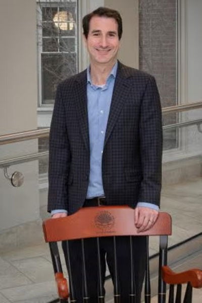 David Wald standing behind his chair