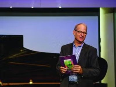 Gary Von Lehmden talking in front of a piano