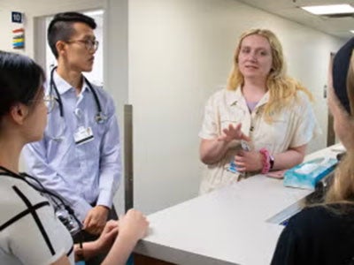 Residents talk around a hospital desk