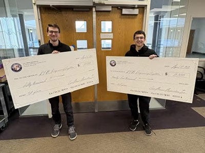 Jesse Silverberg (left) and Ryan Volkin holding big checks
