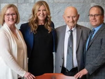 Left to right, standing in front of the named chair: Anne Templeton Zimmerman’s daughter, Renee Stirling, MD (MED '95); Eileen Anderson, EdD; Gail Zimmerman, PhD; and Renee Stirling’s husband, Cory Stirling, MD