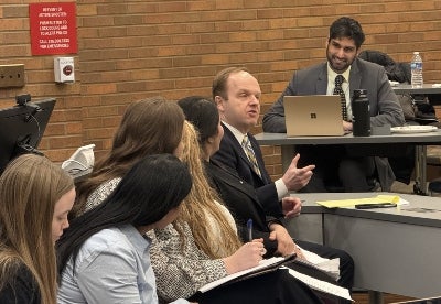 Eric Chaffee speaking while seated among a group of students