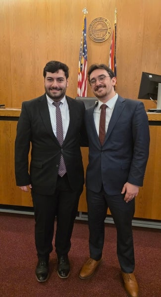 Zach Paganini and Carter Callender standing in a court room