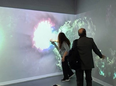 Two people touching the wall in a virtual reality room 