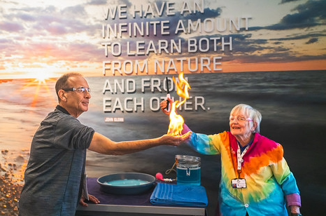 people at the science center holding fire torch 