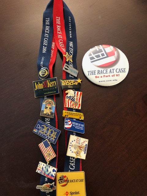 Photo of lanyards full of political pins next to a button promoting the "Race at Case"