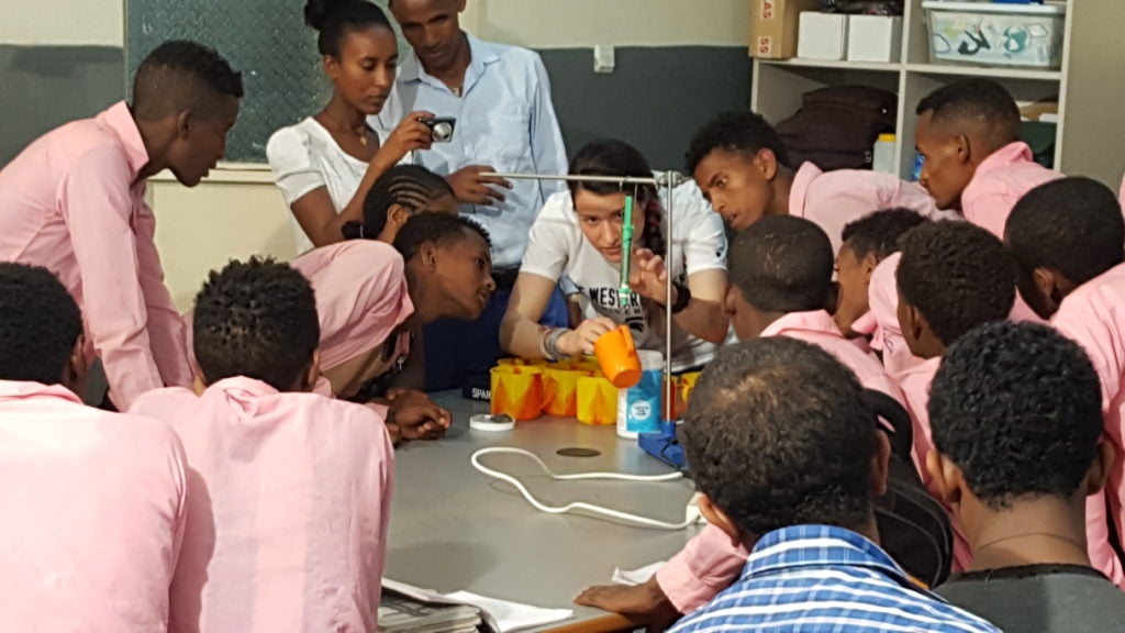 Blaire Volbers leads a science demonstration while surrounded by students in Ethiopia 