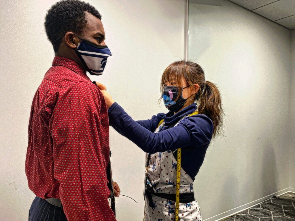 Photo of CWRU costume manager Rainie Jiang fitting a Case Western Reserve University student for a theater costume