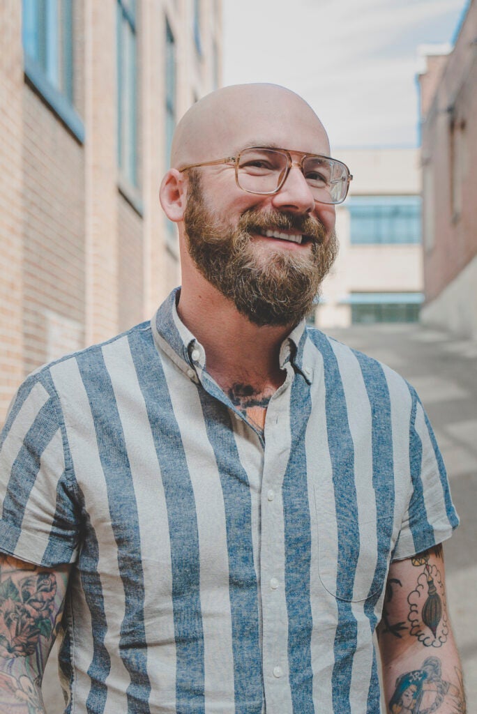 headshot of Aaron Perzanowski outside with brick buildings in the background