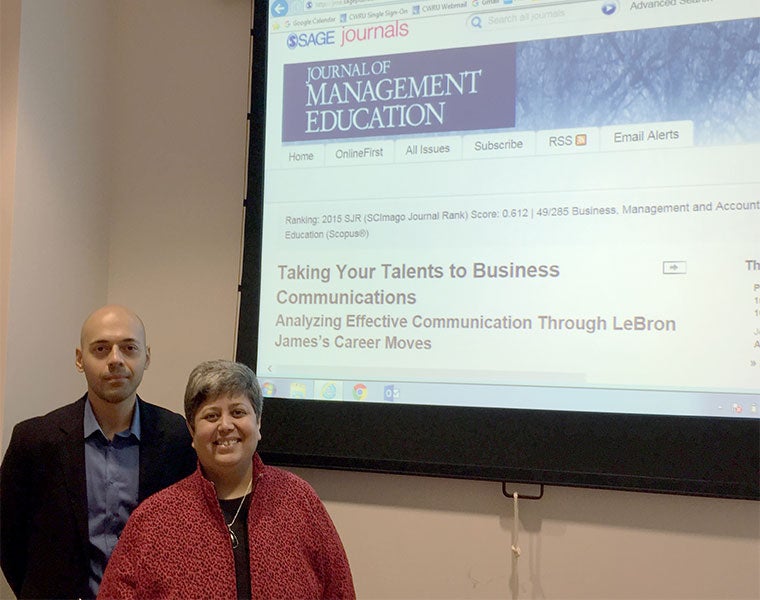 Alperen Manisaligil and Diana Bilimoria stand near a projection of their research paper