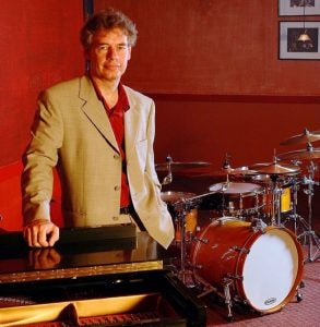 Bill Bruford next to a drumset